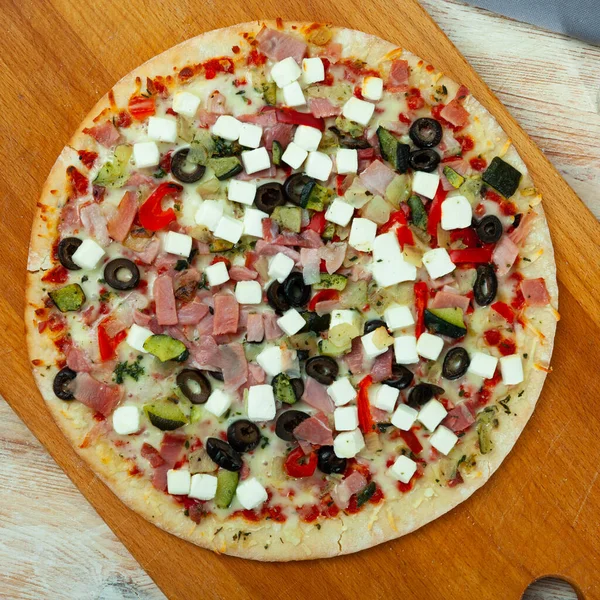 Čerstvě Upečená Pizza Šunkou Zeleným Sýrem Zeleninou Dřevěné Řezací Desce — Stock fotografie