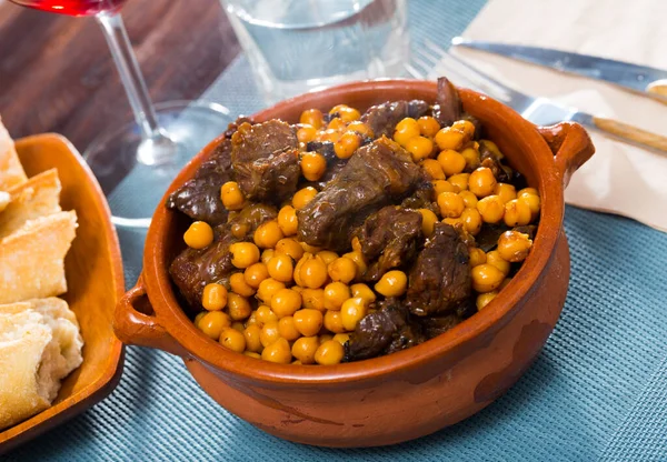 Appetizing stewed beef with chickpea served in clay bowl
