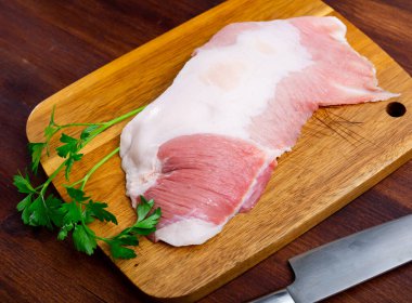 Raw slice of Iberian pork secret, small piece cut between shoulder and bacon of pig on wooden cutting board with seasonings. Deli meats clipart