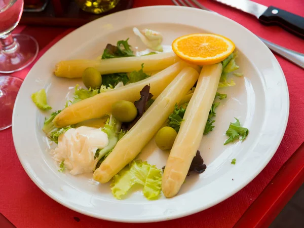 伝統的なヨーロッパのベジタリアン料理の焼き白アスパラガスのガーリックソース オレンジのスライス 緑とオリーブ — ストック写真