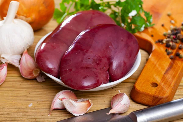 用新鲜蔬菜 蔬菜和香料在木制表面上烹调的生猪肾 — 图库照片