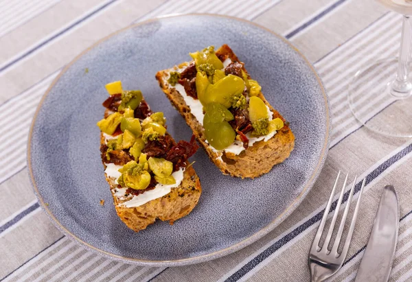 早餐或午餐健康三明治 配上烤面包 奶油芝士 晒干的西红柿片 青橄榄和比索 地中海风格的素食开胃菜 — 图库照片