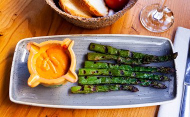 Delicious asparagus appetizer with Romesco sauce on a platter clipart