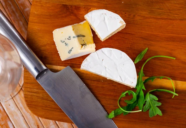 木制切菜板上的软蓝色奶酪片 — 图库照片