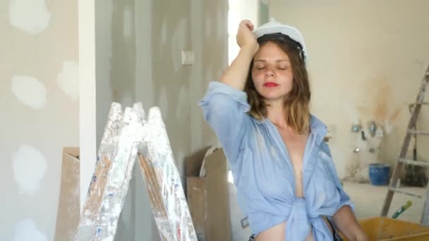 Jonge Verleidelijke Vrouw Met Onthullende Kleren Een Helm Poserend Trapladder — Stockvideo