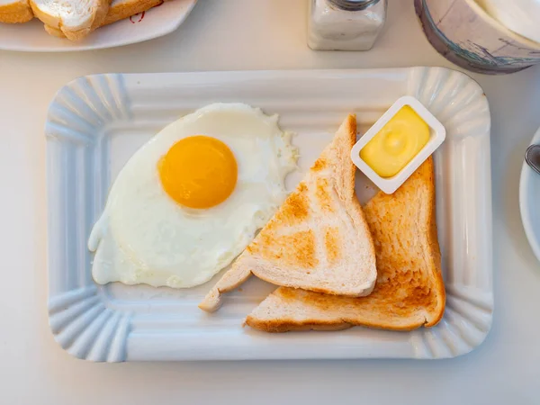 英式早餐 由煎蛋 烤薄面包和黄油制成 放在咖啡店的瓷盘上 — 图库照片
