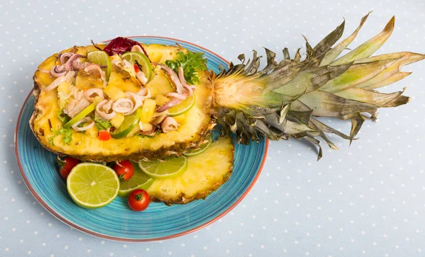 Delicious salad with calamari, pineapple and lime filled with sauce of olive oil, chili pepper with pineapple and lime juice