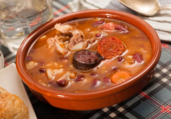 Fabada Asturana コリゾとベーコンで煮込んだ豆を粘土鍋で提供します — ストック写真