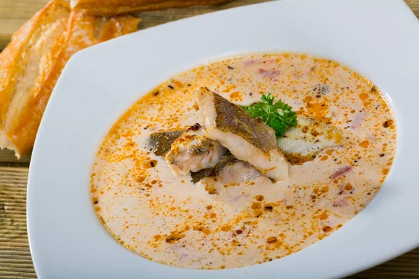 在白盘上用白鱼 鳕鱼和青菜做的美味汤 — 图库照片