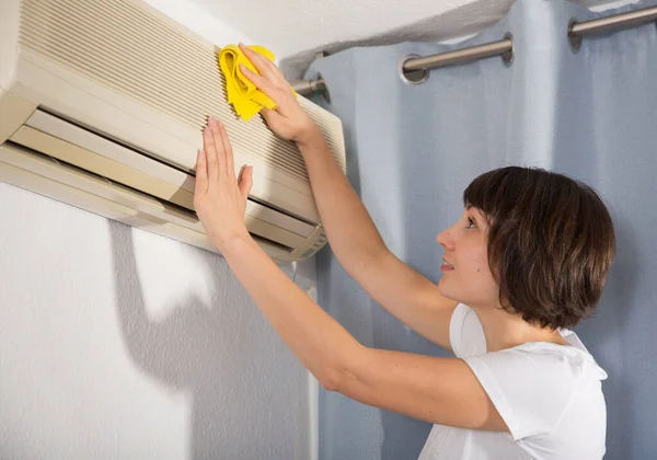 家のエアコンを洗っているブルネットの女性 — ストック写真