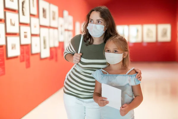 站在艺术博物馆里看绘画的戴着医疗面具的女孩的画像 — 图库照片