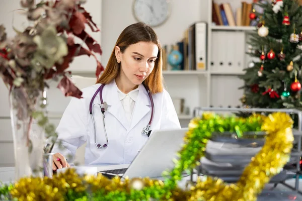 Positive Woman Doctor Working Medical Office Using Laptop Computer Christmas — Fotografia de Stock