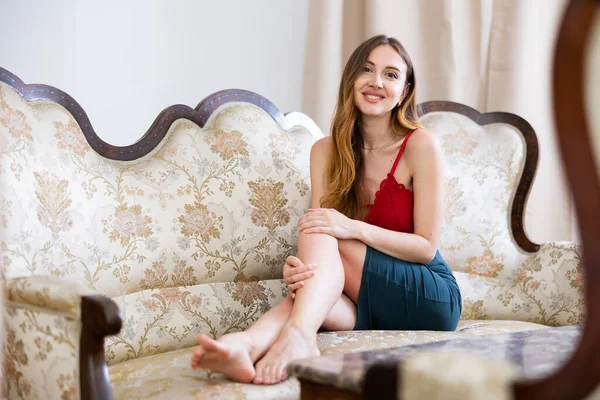 Oturma Odasındaki Kanepede Dinlenen Gülümseyen Genç Kadın Rahatlığın Rahatlığın Tadını — Stok fotoğraf