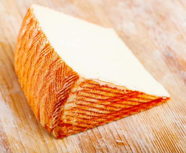 木材表面上の新鮮なスペインチーズのセクター — ストック写真