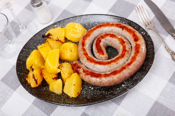 stock image Roasted botifarra, Spanish sausage, cooked with potatoes and served on plate.