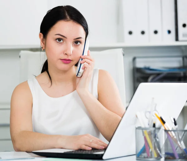 Ofiste Çalışırken Telefonla Konuşan Genç Bir Bayan Işçi — Stok fotoğraf