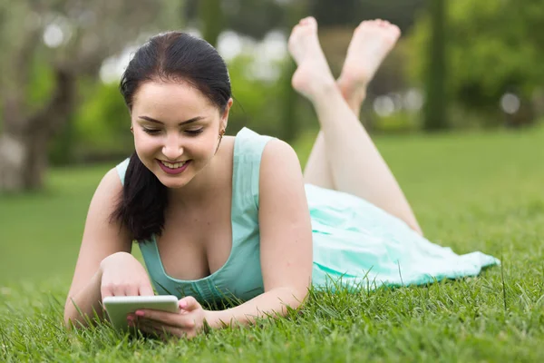 Glimlachend Jong Meisje Met Behulp Van Digitale Tablet Terwijl Liggend — Stockfoto