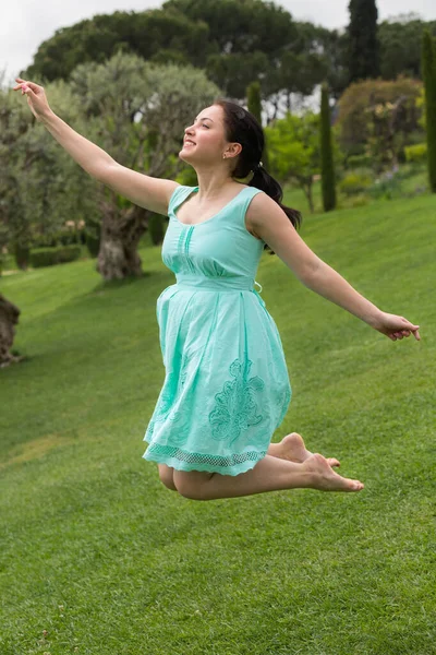 Parkta Atlayan Elbiseli Esmer Mutlu Bir Kadın — Stok fotoğraf