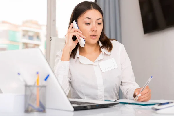 Młoda Kobieta Korzystająca Laptopa Rozmawiająca Przez Telefon Przy Stole Biurowym — Zdjęcie stockowe