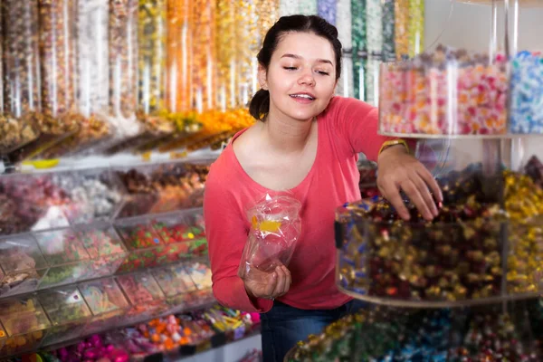 商店里的小女孩正在手工拿糖果包起来 — 图库照片
