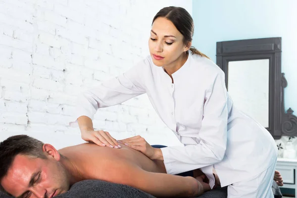 Massaggiatrice Professionista Che Esegue Massaggio Alla Schiena Cliente Maschio Positivo — Foto Stock
