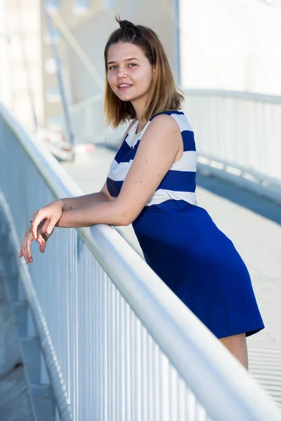 Młoda Pozytywna Dziewczyna Niebieskiej Sukience Stojąca Nowoczesnym Moście Miejskim — Zdjęcie stockowe