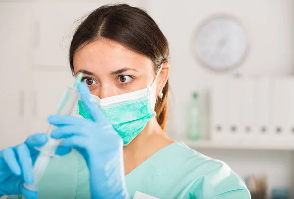 若い女性看護師でマスク保持注射用注射器で病院 — ストック写真