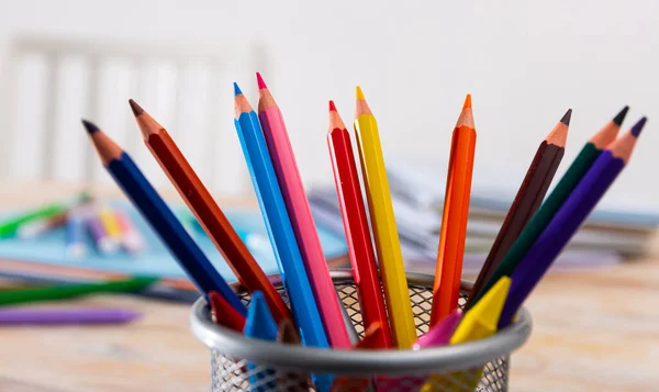 木製のテーブルの上の様々な色の鉛筆やノート — ストック写真