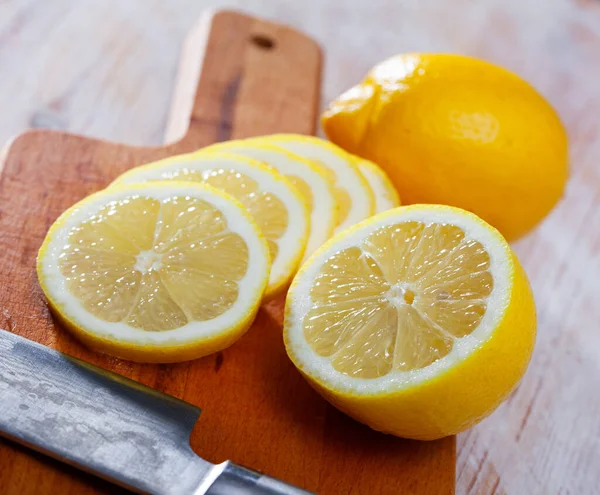 木のテーブルの上で新鮮なジューシーなレモンをスライス 柑橘類の健康上の利点の概念 — ストック写真