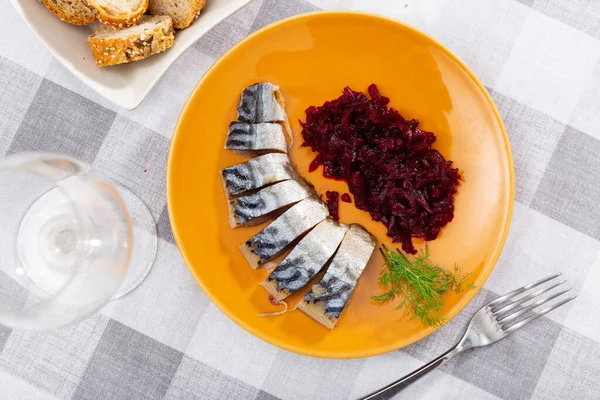 Sliced cold-smoked mackerel fish with boiled beet salad, garnished with fresh dill