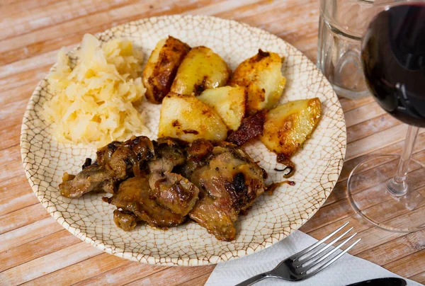 Rabbit liver dish with boiled potatoes and sauerkraut