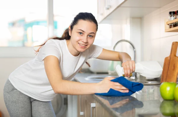 Frau Mit Handtuch Und Sprühwaschmittel Reinigt Küchenarbeitsplatte — Stockfoto