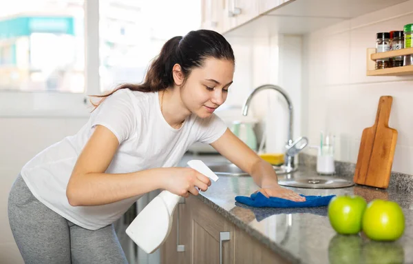 Młoda Kobieta Sprzątanie Powierzchni Kuchennych Pomocą Gąbki Spray — Zdjęcie stockowe