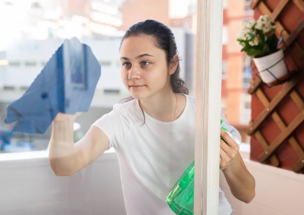 若いです正ヨーロッパの女性洗浄窓とともにスプレーボトルとラグで晴れた日 — ストック写真