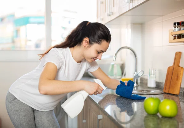 Jovem Mulher Limpeza Superfícies Cozinha Usando Esponja Spray Limpeza — Fotografia de Stock