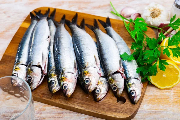 stock image Raw sardines on wooden cutting board in restaurant