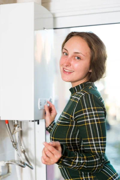 Smiling Woman Adjusting Gas Water Heater Home — 图库照片