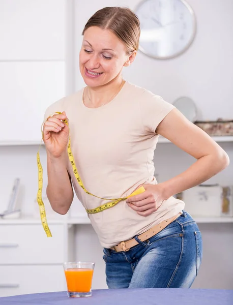Sorrindo Jovem Mulher Medindo Cintura Com Fita Amarela — Fotografia de Stock