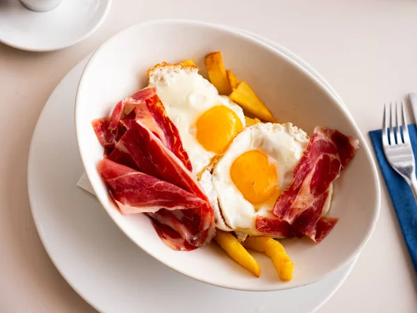 伝統的なスペインの揚げ卵Huevoロートには 薄切りの硬化ジャモンとクリスピーフライが添えられています — ストック写真