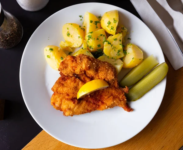 Czech dish - chicken cutlet in breading, potatoes and marinated cucumber