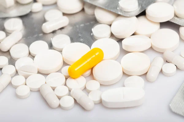 Nahaufnahme Einer Orangefarbenen Medikamentenkapsel Auf Dem Hintergrund Mit Verschiedenen Weißen — Stockfoto