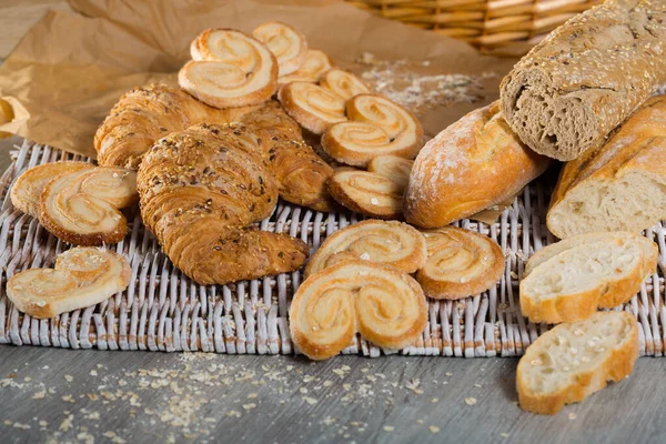 Assortment Fresh Baked Goods Wicker Mat Basket Wooden Background — Stock Photo, Image