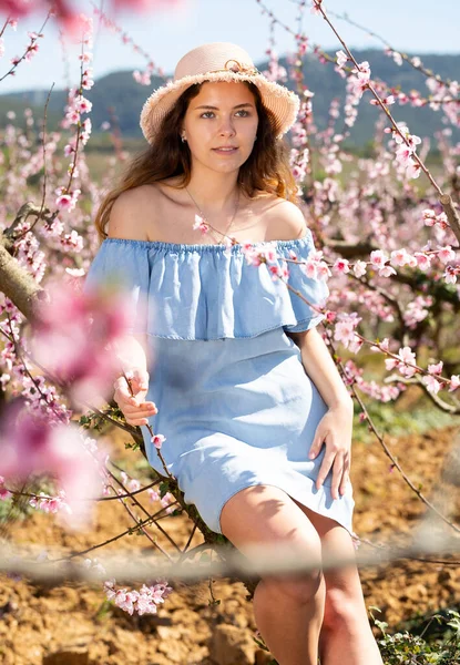 在一个桃树盛开的花园里 一个年轻微笑的女人的画像 — 图库照片