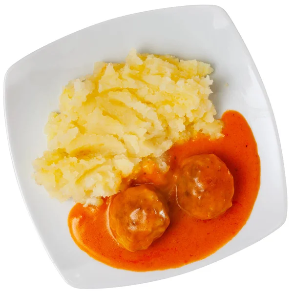 on square plate,portion of a hearty lunch - creamy mashed potatoes with round minced chicken meatballs with tomato sauce. Isolated over white background