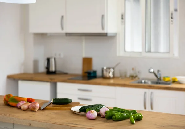 在厨房的背景下 用刀叉和一些蔬菜在桌面上切木板 — 图库照片