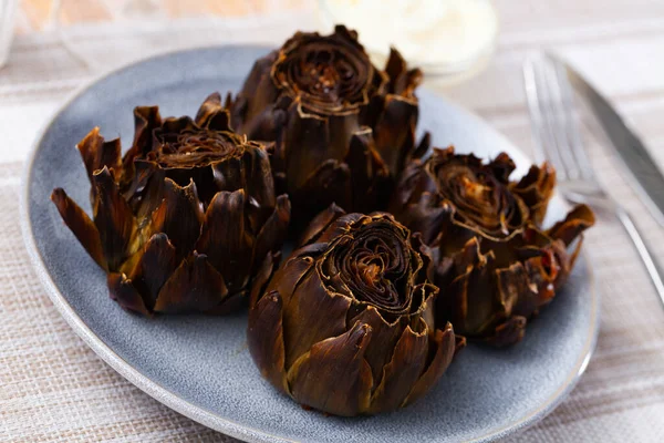 stock image Whole roasted artichokes on plate served as healthy vegetable dinner