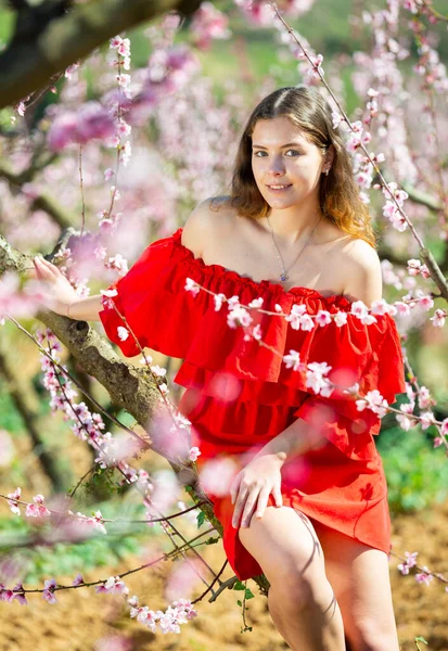 Χαρούμενο Κορίτσι Που Ποζάρει Κόκκινο Φόρεμα Ανοιξιάτικη Ανθοφορία — Φωτογραφία Αρχείου