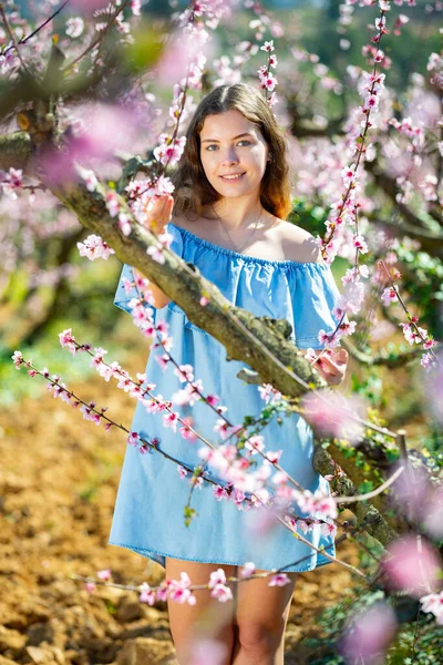 Kvinne Blå Kjole Med Sjarmerende Smil Som Går Blomstrende Park – stockfoto