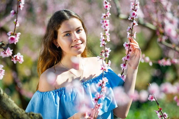 Žena Modrých Šatech Okouzlujícím Úsměvem Kráčející Kvetoucím Parku Těší Jarní — Stock fotografie
