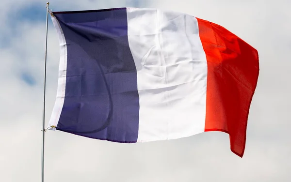 平等と友愛を象徴する鮮やかな青 赤のフランスの三色は 晴れた日に曇った空に対して旗竿に振っています 国家の誇り 文化の概念 — ストック写真